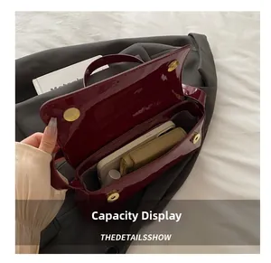 Detailed interior view of a glossy burgundy baguette bag showing daily essentials storage