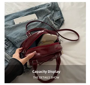 Spacious interior of burgundy patent leather bowling bag showing daily items