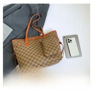 Dettaglio della grande borsa tote a scacchi con borsellino coordinato e laptop di scala