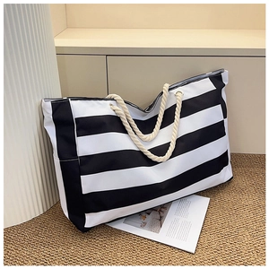 Close-up of a striped canvas tote bag featuring thick cotton rope handles and metal eyelets