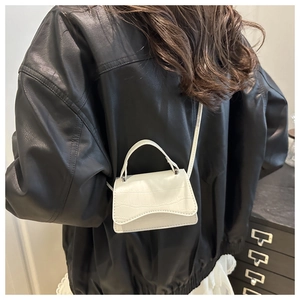 Détail du mini sac blanc à texture crocodile et rabat ondulé avec poignée supérieure