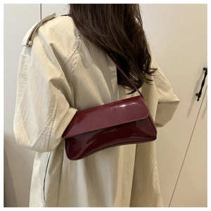 Glossy burgundy PU leather crossbody bag worn by a model against a neutral background