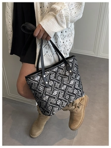 Detailed shot of retro floral jacquard tote bag with black leather handle and rivets
