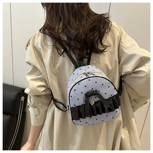 Detailed back view of a light blue striped mini backpack with black heart patterns