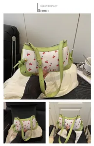 Detail of green trim and cherry print on a stylish faux leather underarm shoulder bag