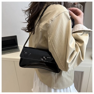 Détail du sac à bandoulière en cuir verni noir brillant avec effet miroir et texture fine