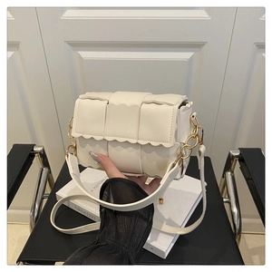 Detail of cross-woven crossbody bag with unique scalloped edges and gold hardware