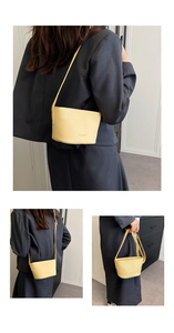 Detail view of bright yellow bucket bag with lychee grain texture and fashion embossing