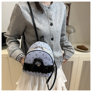 Detail of blue striped canvas mini backpack with black heart prints and ribbon decor