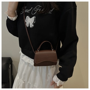 Detail view of brown crocodile embossed mini crossbody bag with leather strap