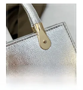 Close-up of silver crackle leather texture and gold-tone metal handle hardware detail