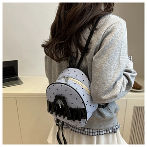 Close-up of a blue striped mini backpack with black bows and ruffles on a model