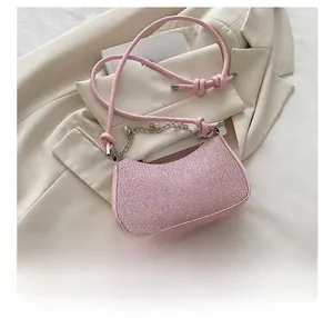Close-up of pink sequined crossbody bag with silver chain and faux pearl detail