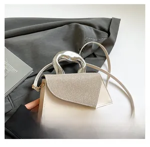 Detail of white leather handbag featuring diamond-encrusted flap and silver lava metal handle