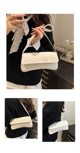 Detail shot of the glossy white patent leather surface and sleek rectangular baguette shape