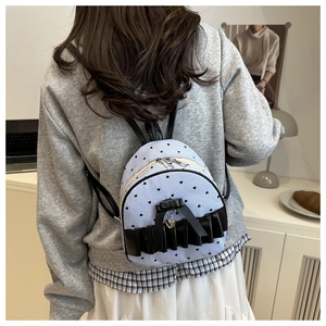 Mini striped backpack with heart prints and black bow detail shown on a model