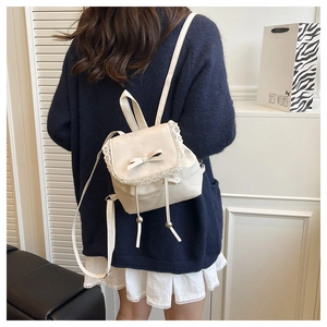 Close-up of cream PU leather backpack with lace trim and bow knot detail on the flap