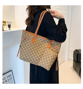 Dettaglio della borsa tote nei toni della terra con motivo a scacchi vintage e tracolla lunga