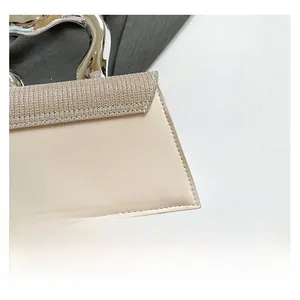 Detail of irregular silver metal handle and beige leather texture on fashion handbag