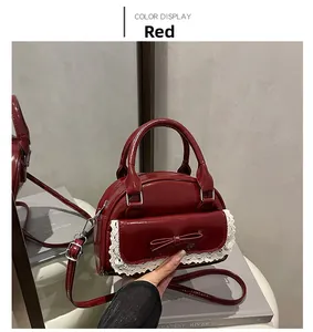 Detail view of red glossy bowling bag with lace trim and bow reflected in mirror