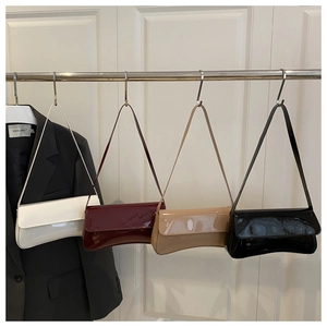 Detailed display of four glossy patent leather baguette bags in various retro colors