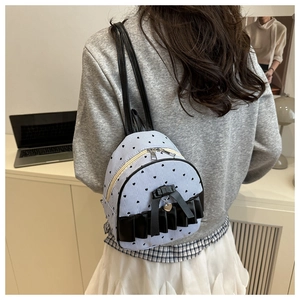 Mini blue striped backpack with heart print, black ruffles and bow on a model