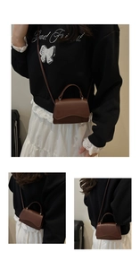 Detail of a brown crocodile pattern flap bag with wavy edges and adjustable strap