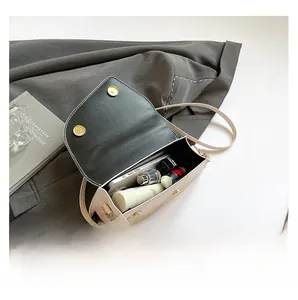 Interior view of beige crossbody bag showing space for phone, lipstick and cosmetics