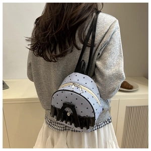 Close-up of blue striped canvas mini backpack with heart patterns and bow detail