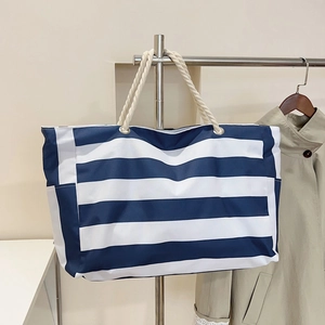 Large blue and white striped canvas tote bag with thick rope handles and metal eyelets