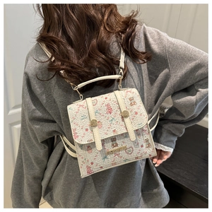 Close-up of white embossed PU backpack featuring cute cartoon prints and metal twist lock