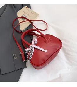 Detail of red bowling bag showing bow decoration and embossed leather texture