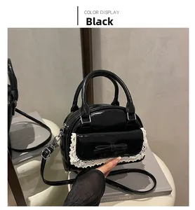 Detail of black patent leather bowling bag with white lace trim and bow accent