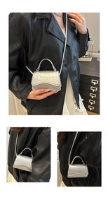 Detail of silver crocodile pattern mini crossbody bag with top handle and sleek strap
