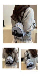 Detail of light blue mini backpack with black heart patterns and ruffled bow decoration