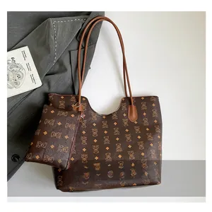 Détail d'un sac cabas marron et d'une pochette assortie avec motifs d'ours et losanges