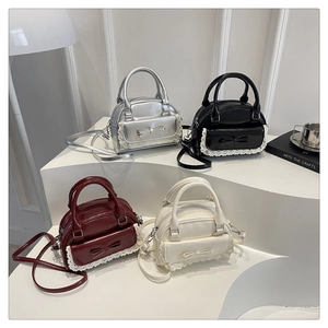 Chic bowling handbags in four colors with lace and bow details on white tiered display