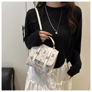 Detailed view of floral crossbody bag with cute animal patterns and metal buckle
