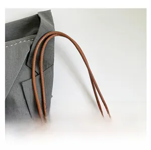 Détail de la bandoulière en cuir marron avec coutures soignées sur un sac cabas chic