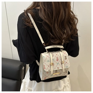 Detail of white floral backpack with cute bear print and metallic logo on the back