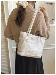 Detail view of ethnic embroidery patterns on a white large-capacity tote bag