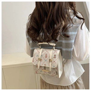 Close-up of cute cartoon pattern details on a white leather backpack with metal logo