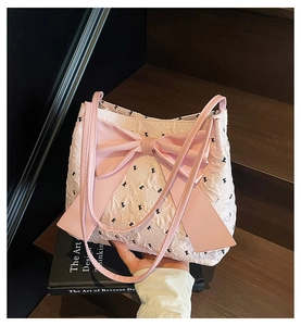 Detail of pink ruffled fabric tote bag with large bow and black floral print