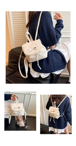 Detail of cream backpack with lace trim, bow decoration and silver drawstring metal beads