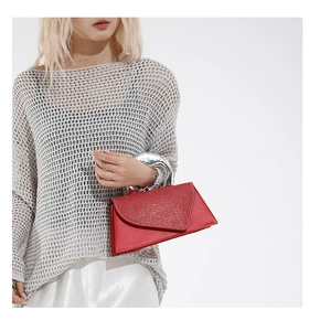 Detail of red geometric handbag with sparkling lid and silver round metal handle
