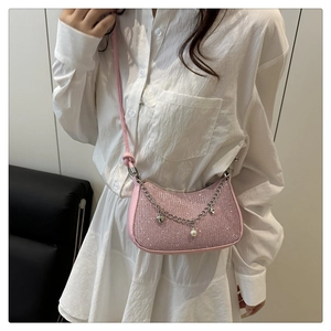 Détail du sac croissant à paillettes roses avec chaîne argentée et breloques en perles