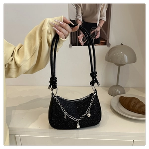 Détail du sac à paillettes noires avec chaîne argentée et breloques en perles