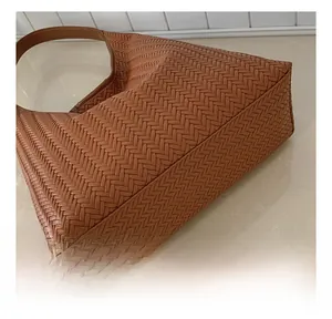 Macro detail of brown woven tote bag showing premium leather stitching and texture