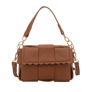 Sac bandoulière tressé marron avec bords ondulés et chaîne dorée sur fond blanc