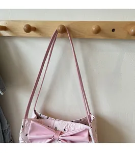 Detail of pink tote bag showing large decorative bow and soft pleated texture